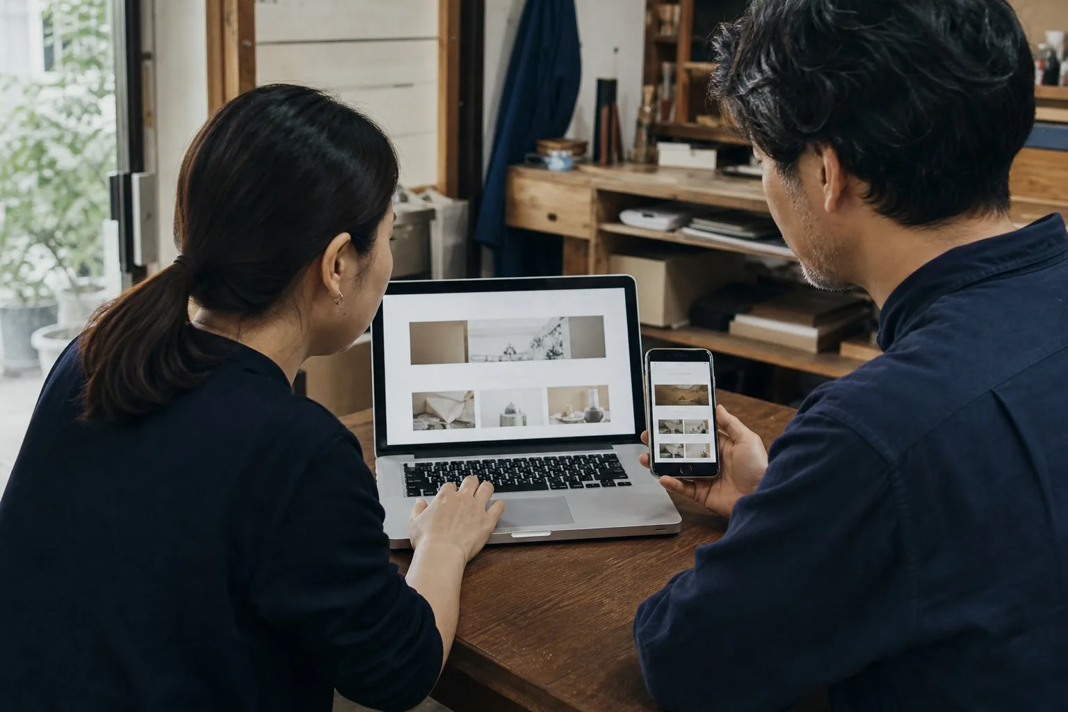 ノートパソコンとスマートフォンでWebサイトを確認する様子